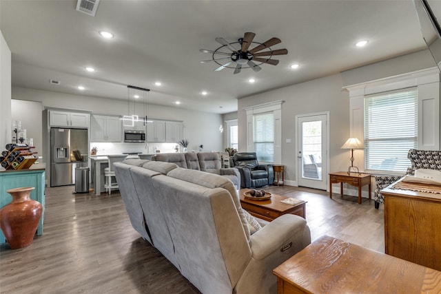 living area featuring wood finished floors, visible vents, a ceiling fan, and recessed lighting