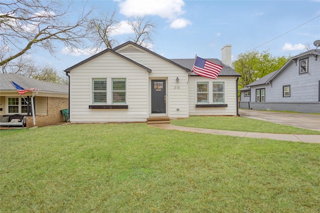 bungalow-style house featuring a front lawn and a chimney