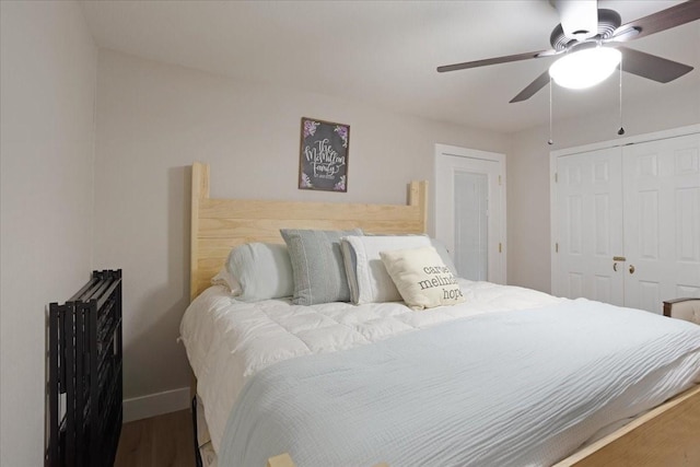 bedroom featuring a ceiling fan, baseboards, a closet, and wood finished floors