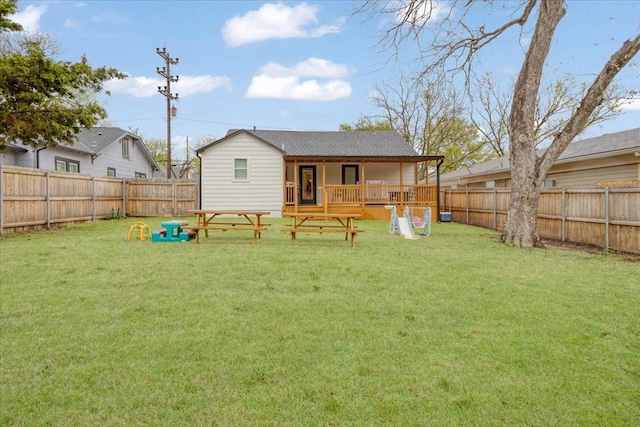 back of house featuring a fenced backyard and a lawn