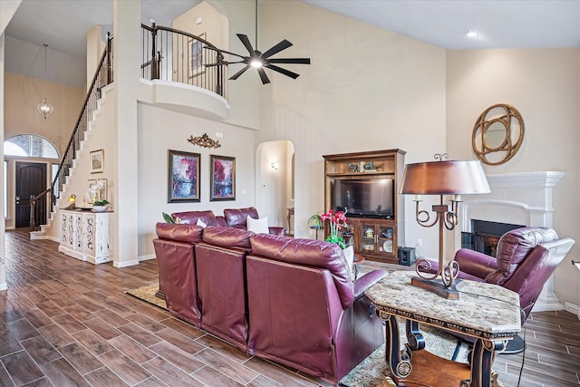 208 Equestrian Ln, Hickory Creek, TX 75065 - living area with arched walkways, high vaulted ceiling, a fireplace, a ceiling fan, and stairs
