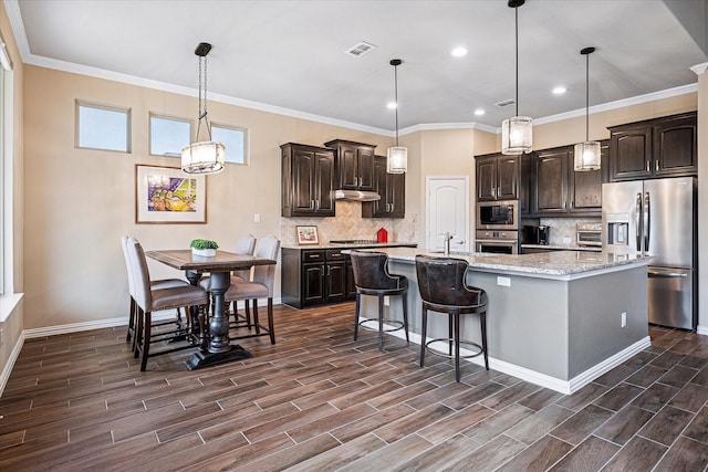 208 Equestrian Ln, Hickory Creek, TX 75065 - kitchen with appliances with stainless steel finishes, under cabinet range hood, dark wood-style floors, backsplash, and recessed lighting