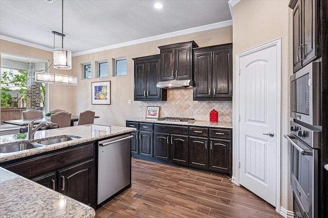 208 Equestrian Ln, Hickory Creek, TX 75065 - kitchen with stainless steel appliances, under cabinet range hood, ornamental molding, backsplash, and light stone counters