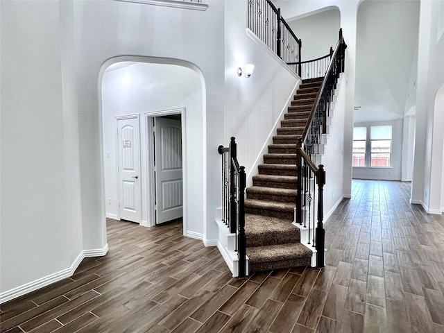 208 Equestrian Ln, Hickory Creek, TX 75065 - staircase featuring wood finished floors, arched walkways, and a towering ceiling