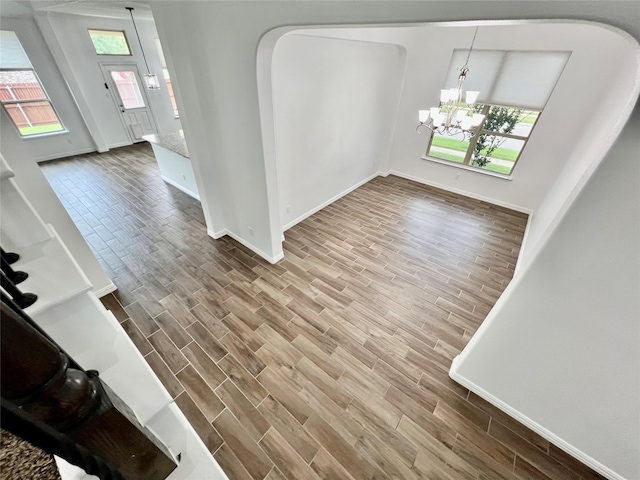 208 Equestrian Ln, Hickory Creek, TX 75065 - unfurnished dining area featuring wood finished floors, arched walkways, healthy amount of natural light, and a chandelier