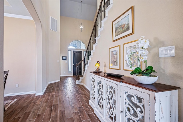 208 Equestrian Ln, Hickory Creek, TX 75065 - entrance foyer featuring arched walkways, dark wood finished floors, stairs, a high ceiling, and ornamental molding