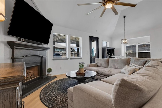 817 Layla Dr, Fate, TX 75087 - living room featuring ceiling fan, a fireplace with raised hearth, a chandelier, high vaulted ceiling, and wood finished floors