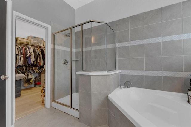817 Layla Dr, Fate, TX 75087 - bathroom with a garden tub, a shower stall, a spacious closet, and tile walls