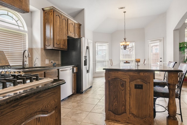 6417 Belhaven Dr, Fort Worth, TX 76123 - kitchen with visible vents, a kitchen island, dark countertops, stainless steel appliances, and tasteful backsplash