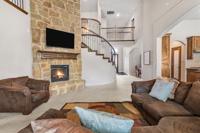 6417 Belhaven Dr, Fort Worth, TX 76123 - living room with carpet, arched walkways, a stone fireplace, and visible vents