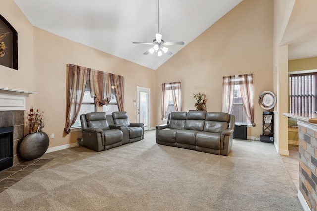 carpeted living room with a ceiling fan, a tile fireplace, high vaulted ceiling, and baseboards
