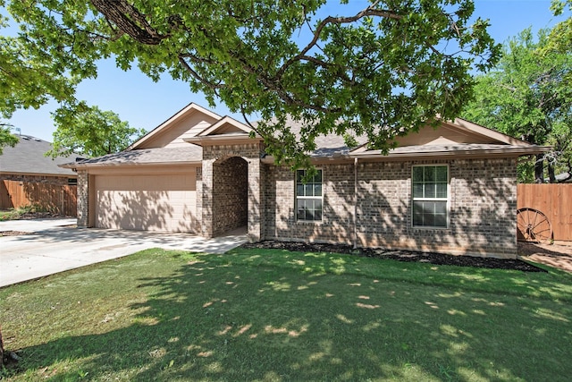 207 Shady Oaks Dr, Runaway Bay, TX 76426 - view of front of home with concrete driveway, a front yard, brick siding, and an attached garage
