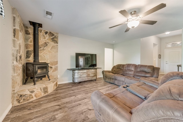 207 Shady Oaks Dr, Runaway Bay, TX 76426 - living room featuring visible vents, baseboards, a wood stove, ceiling fan, and wood finished floors