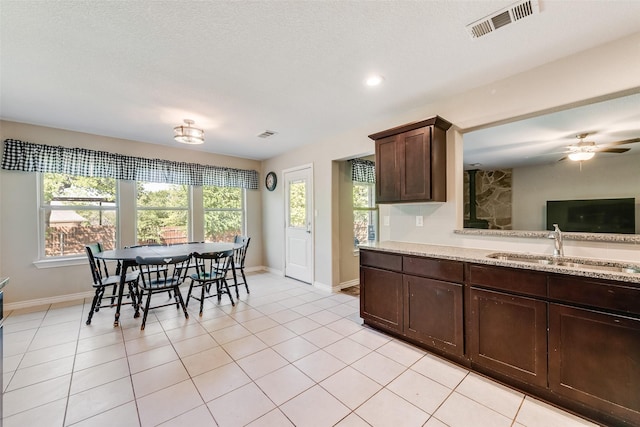 207 Shady Oaks Dr, Runaway Bay, TX 76426 - kitchen with a sink, visible vents, light tile patterned flooring, and dark brown cabinets