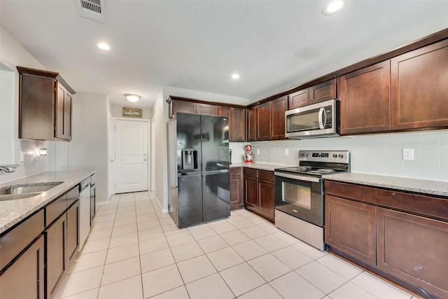 207 Shady Oaks Dr, Runaway Bay, TX 76426 - kitchen featuring tasteful backsplash, visible vents, a sink, light stone countertops, and stainless steel appliances