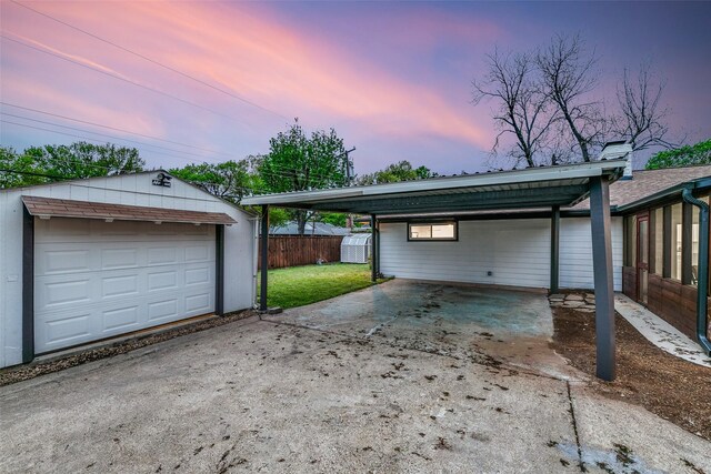 10606 Estate Ln, Dallas, TX 75238 - garage at dusk with driveway and a detached carport