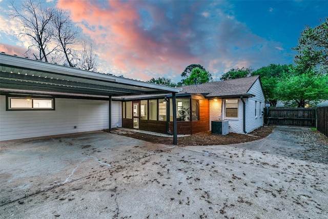 10606 Estate Ln, Dallas, TX 75238 - rear view of property with fence, central AC unit, brick siding, and a carport