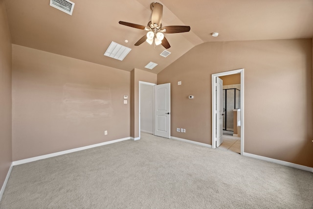 unfurnished bedroom with baseboards, lofted ceiling, light colored carpet, and visible vents