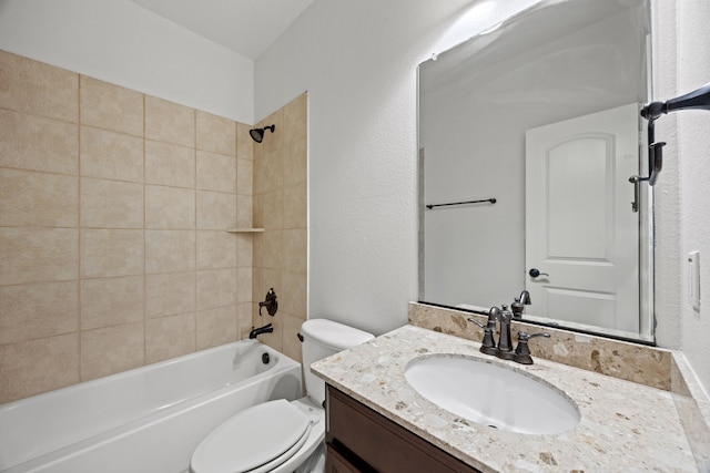 bathroom with vanity, a textured wall, bathing tub / shower combination, and toilet