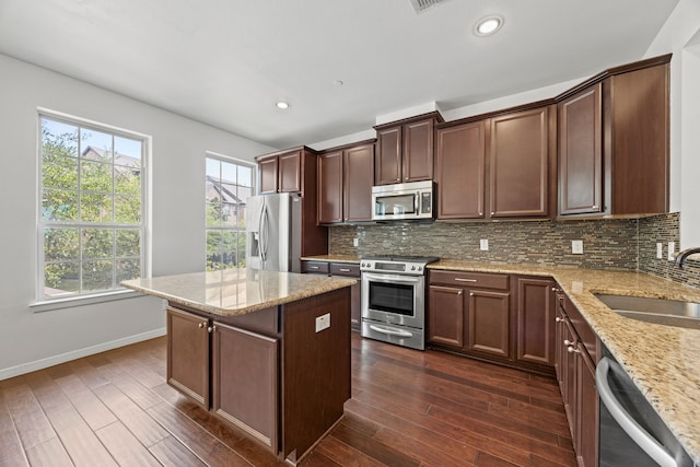 kitchen featuring a sink, decorative backsplash, dark wood-style floors, and stainless steel appliances