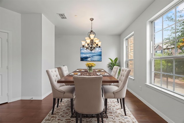 dining space with baseboards, a chandelier, dark wood finished floors, and visible vents