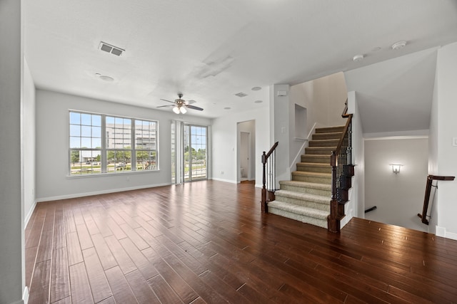 unfurnished living room featuring ceiling fan, dark wood finished floors, plenty of natural light, and visible vents