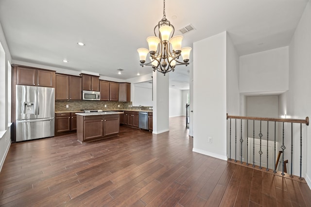 kitchen featuring visible vents, a kitchen island, a chandelier, appliances with stainless steel finishes, and backsplash