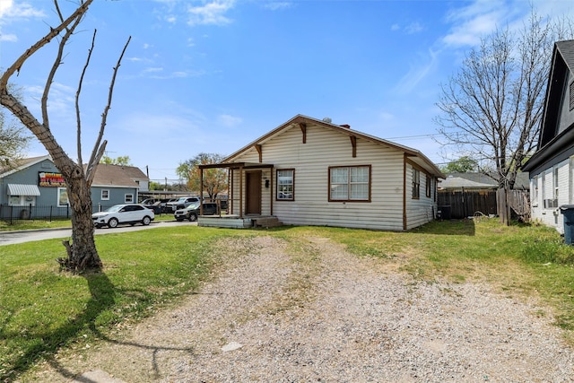 view of front of house featuring driveway, a front yard, and fence