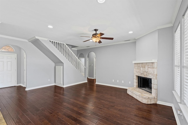729 Ridgeway Blvd, Weatherford, TX 76086 - unfurnished living room featuring arched walkways, a stone fireplace, hardwood / wood-style flooring, a ceiling fan, and ornamental molding