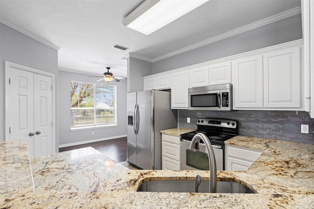 729 Ridgeway Blvd, Weatherford, TX 76086 - kitchen featuring stainless steel appliances, light stone counters, backsplash, white cabinets, and crown molding