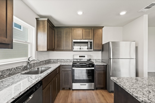 kitchen featuring visible vents, light wood-style floors, a sink, and stainless steel appliances