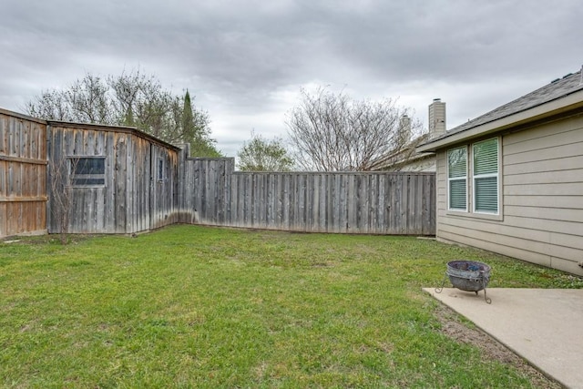 view of yard featuring a patio, a fenced backyard, and an outdoor fire pit