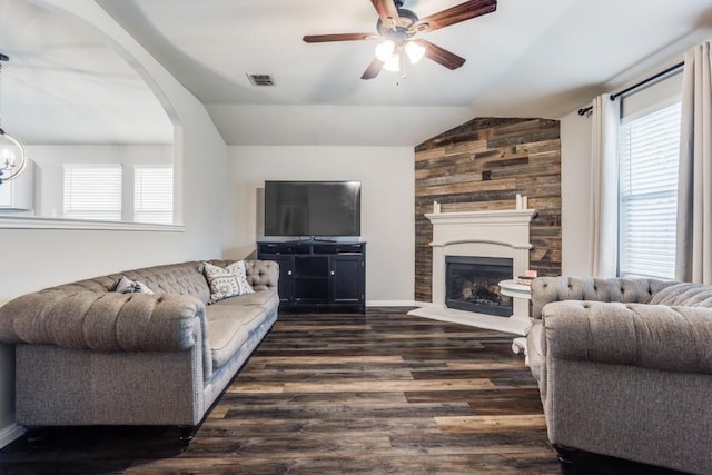 living room with a large fireplace, vaulted ceiling, visible vents, a ceiling fan, and dark wood-type flooring