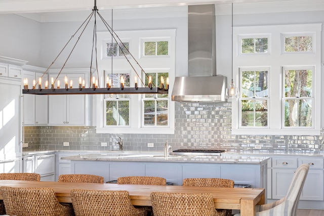 13270 Waterside Dr, Malakoff, TX 75148 - kitchen featuring wall chimney exhaust hood, white cabinetry, backsplash, a sink, and hanging light fixtures
