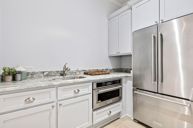 13270 Waterside Dr, Malakoff, TX 75148 - kitchen with appliances with stainless steel finishes, a sink, white cabinets, and light stone countertops