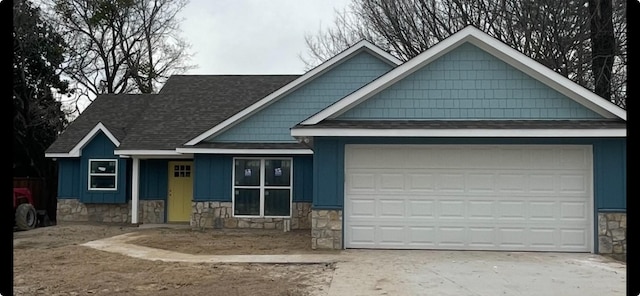 240 Wells St, Emory, TX 75440 - view of front of property with an attached garage, driveway, a shingled roof, and stone siding