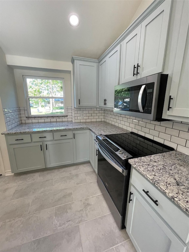 240 Wells St, Emory, TX 75440 - kitchen featuring stainless steel microwave, range with electric stovetop, decorative backsplash, light stone counters, and recessed lighting