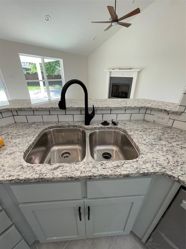 240 Wells St, Emory, TX 75440 - kitchen view of a sink, a ceiling fan, light stone counters, and a fireplace