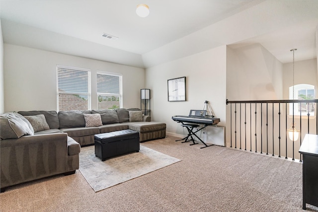 living room with vaulted ceiling, visible vents, and carpet