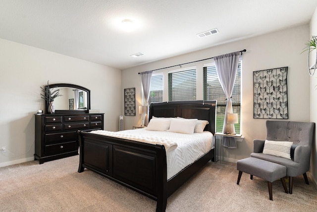 bedroom featuring baseboards, light carpet, and visible vents