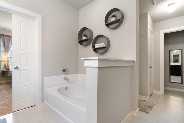 bathroom featuring visible vents, baseboards, tile patterned flooring, and a garden tub