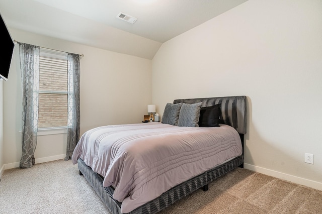carpeted bedroom featuring baseboards, vaulted ceiling, and visible vents