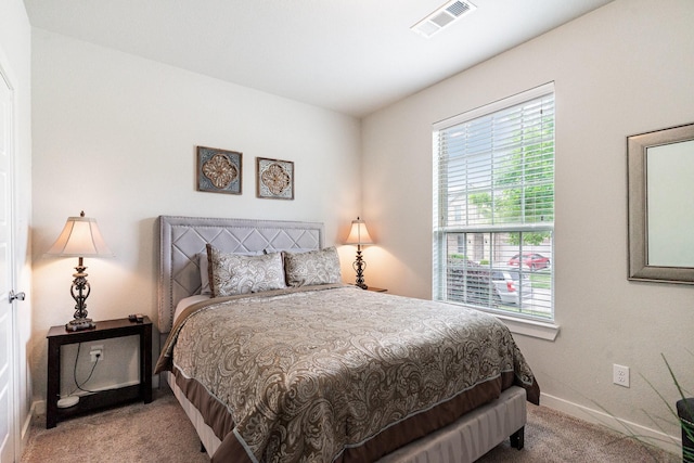carpeted bedroom with baseboards, multiple windows, and visible vents