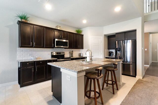 1702 Knollwood Rd, Wylie, TX 75098 - kitchen with stainless steel appliances, a sink, light stone countertops, a kitchen bar, and tasteful backsplash