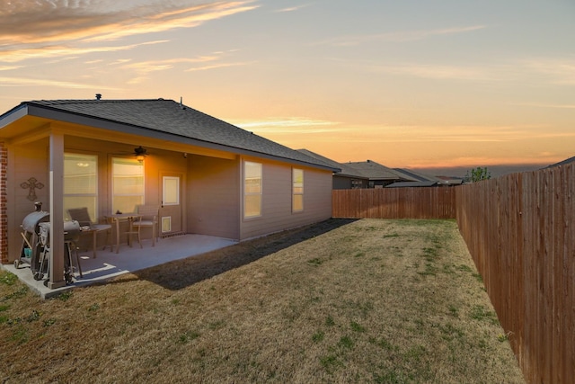 9100 Pearfield Rd, Fort Worth, TX 76179 - back of property at dusk featuring a lawn, a fenced backyard, a patio, and a ceiling fan