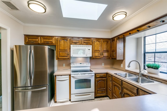 5915 Volunteer Pl, Rockwall, TX 75032 - kitchen featuring white appliances, a sink, a skylight, ornamental molding, and brown cabinets