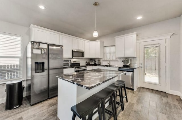 7945 Downe Dr, White Settlement, TX 76108 - kitchen with stainless steel appliances, a sink, white cabinetry, tasteful backsplash, and recessed lighting