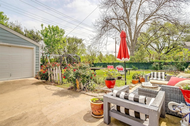 view of patio / terrace with an outdoor living space, an outbuilding, and fence