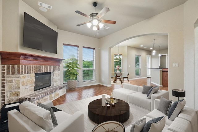 1240 Park Xing, Grand Prairie, TX 75104 - living area with arched walkways, wood finished floors, ceiling fan, baseboards, and a glass covered fireplace