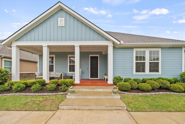view of front of house featuring covered porch, board and batten siding, a shingled roof, and an outdoor living space